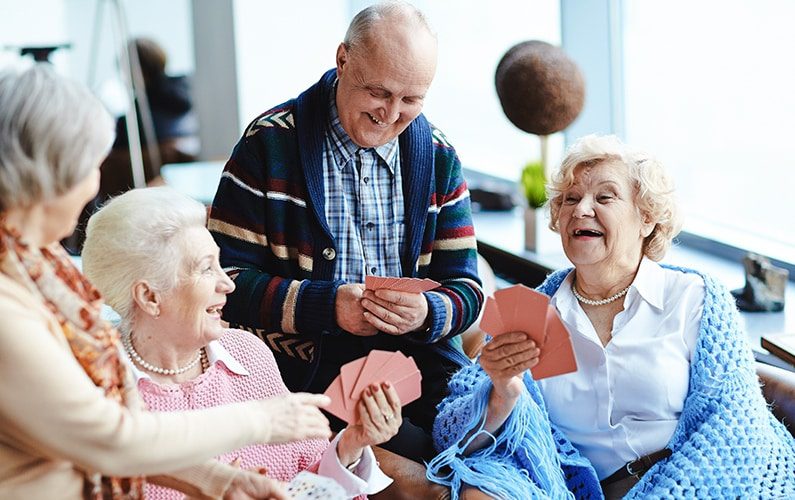 elderly group playing cards showing independent living