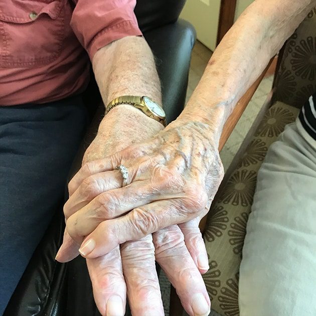 Elderly hands on lap with wedding rings