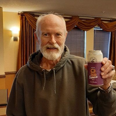 Elderly man holding up a WeldWerks canned beer
