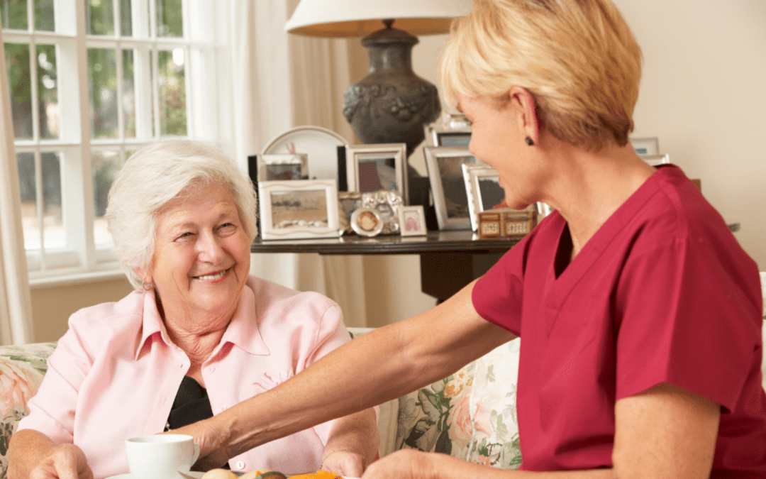 women smiling at an older woman in long term senior care