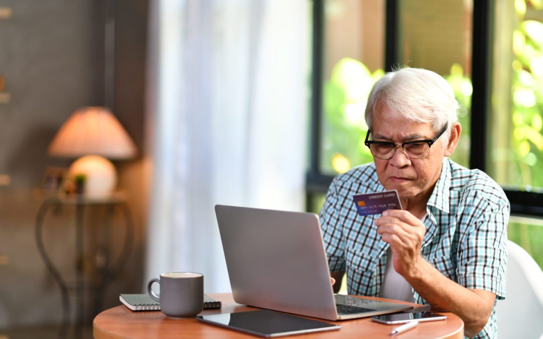 Asian senior man looking confuse when using credit card for onli