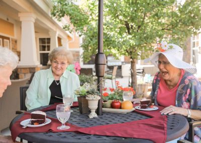 women laughing outside at Grace Pointe Senior Care Community sitting on the patio